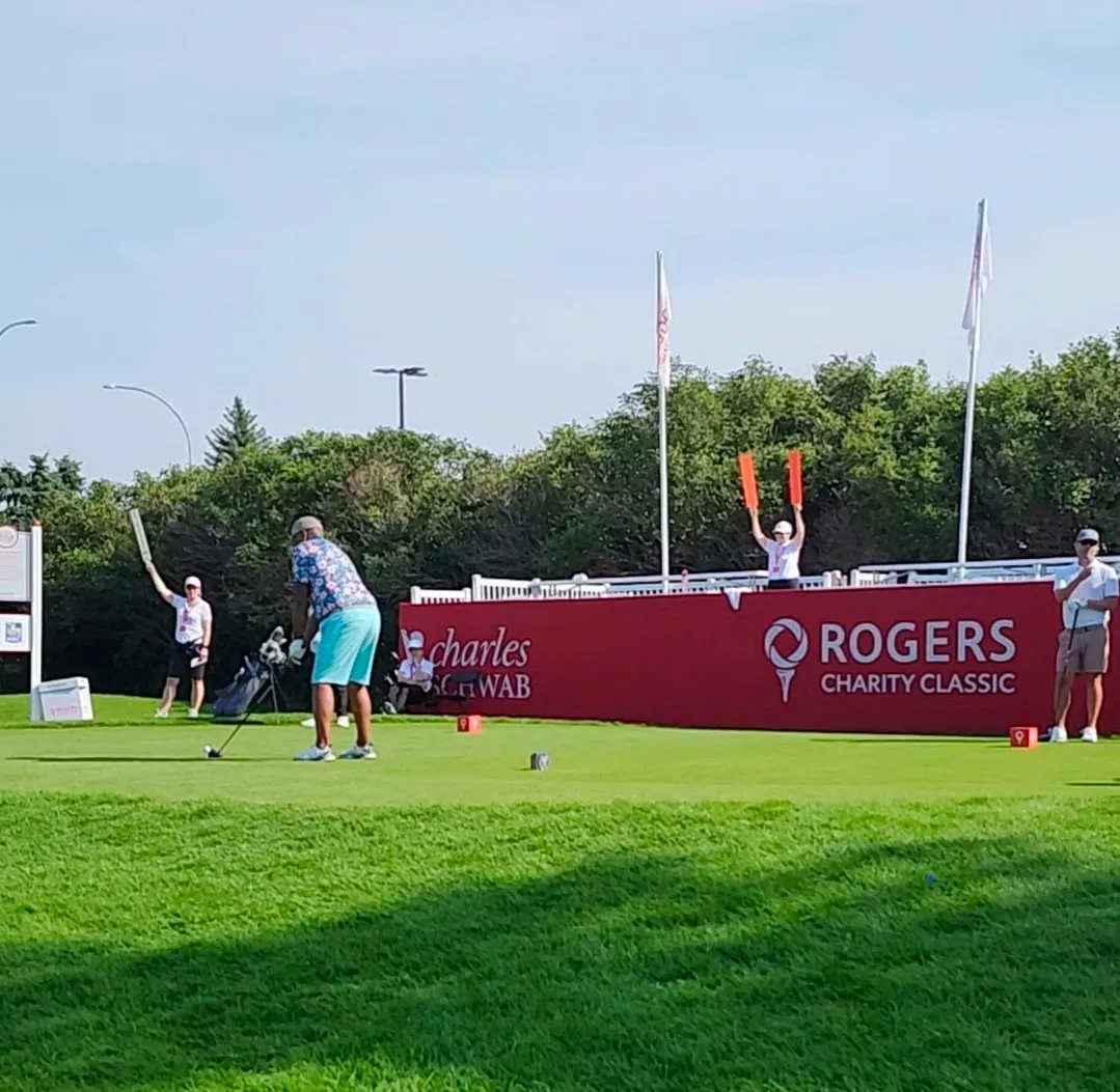 Golfer teeing off in front of Rogers Charity Classic signage